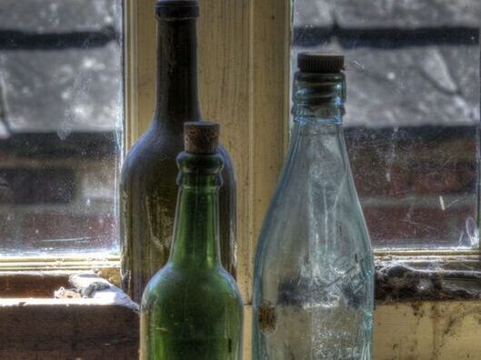 Three antique bottles on windowsill
